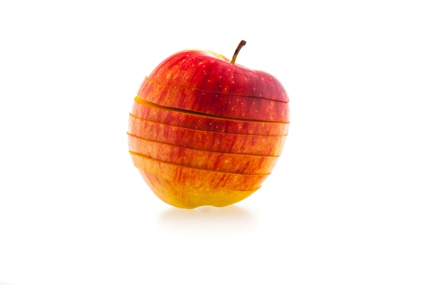 Une pomme rouge juteuse en tranches sur un fond blanc