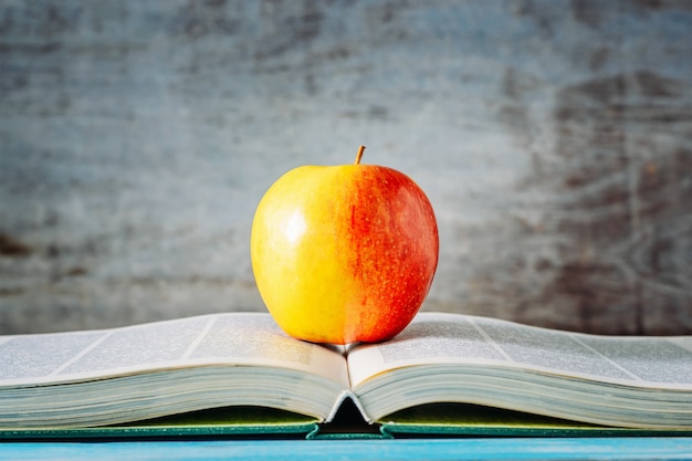 Pomme rouge sur livre ouvert