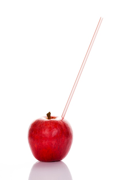 Pomme rouge avec de la paille sur fond blanc