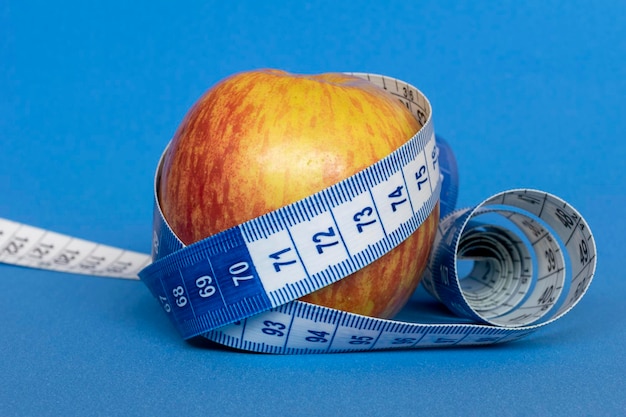 Photo pomme rouge avec ruban à mesurer santé et perte de poids
