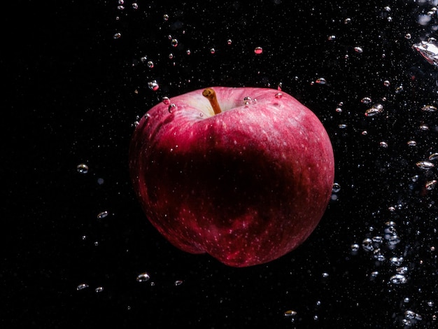 Pomme rouge tombant dans l'eau