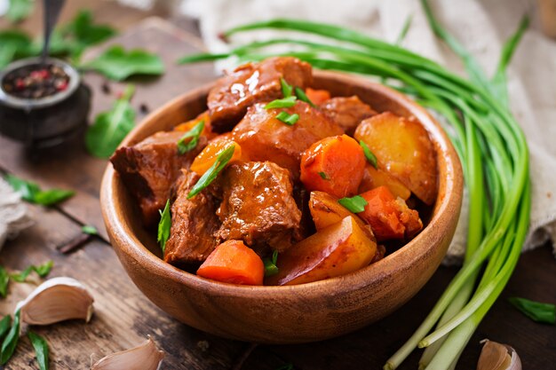 Pomme de terre au four avec du bœuf Bourguignon sur le vieux fond en bois dans un style rustique