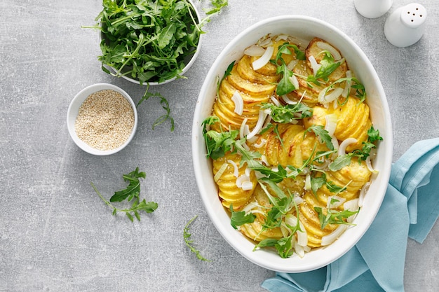 Pomme de terre au four avec oignon et vue de dessus de roquette fraîche