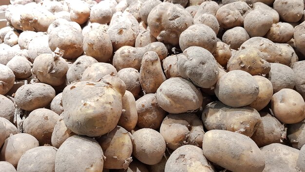 Pomme de terre fraîche avec des traces de terre sur la peau, pommes de terre crues.