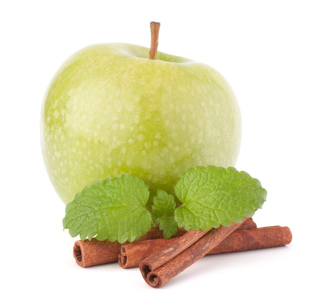 Pomme verte, bâtons de cannelle et feuilles de menthe nature morte isolée sur découpe blanche.