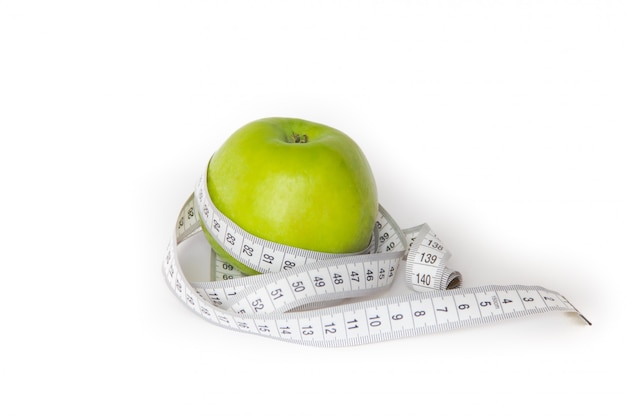 Pomme verte et compteur de mesure isolé sur blanc.