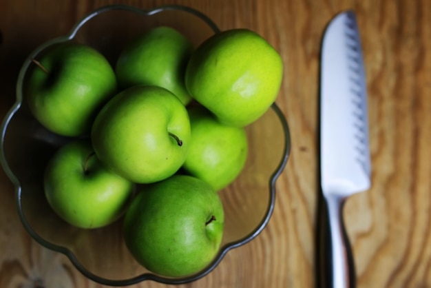 Pomme verte dans un fond en bois de bol en verre