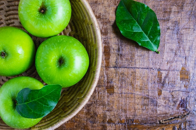 Pomme verte dans un panier sur une table en bois