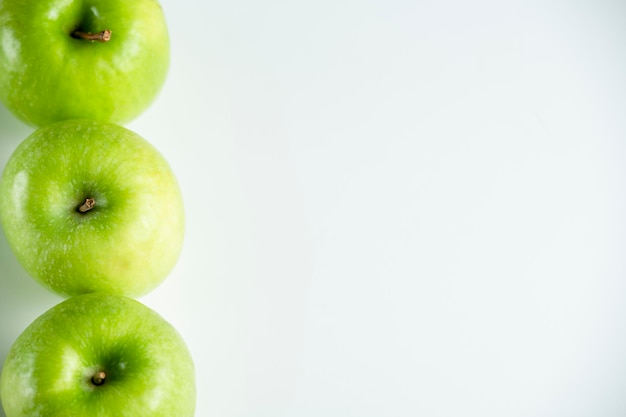 Une pomme verte entière sur un fond blanc