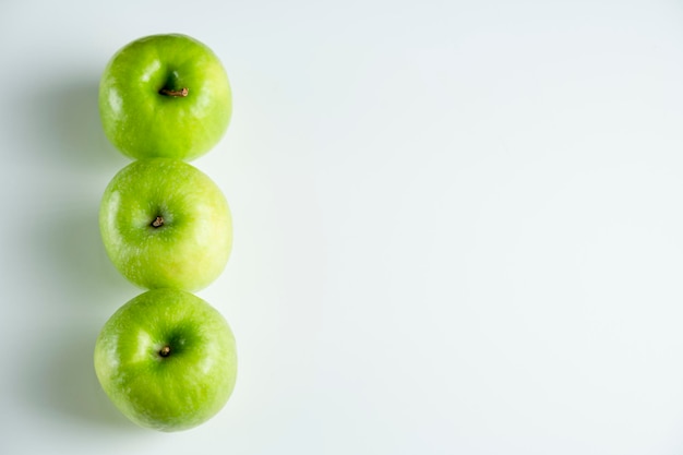 Une pomme verte entière sur un fond blanc