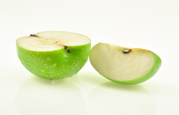 Pomme verte avec goutte d'eau sur blanc.