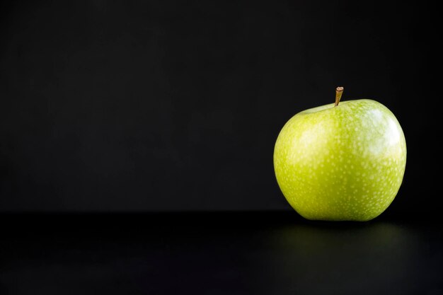 Pomme verte isolée sur fond noir avec espace de copie