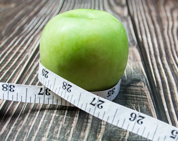 Pomme verte avec mesure Sur le bois