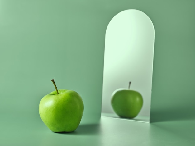 Pomme verte et son reflet dans le miroir