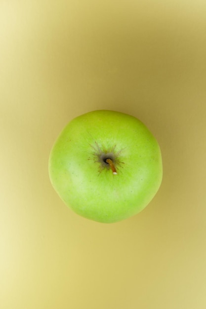 Pomme verte sucrée juteuse sur fond doré Concept d'aliments sains Libre d'un fruit vert Vue de dessus