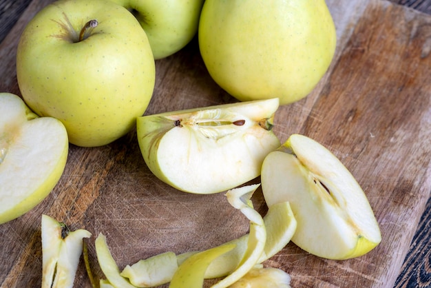 Pomme verte tranchée et pelée sur une planche de bois