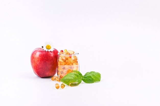 Pomme et vitamines en surface de capsules. Médicaments et médicaments pour la santé