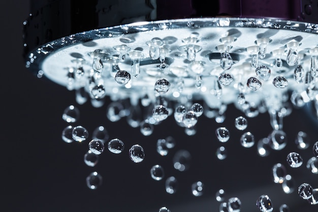 Pommeau de douche avec jet d'eau sur fond noir