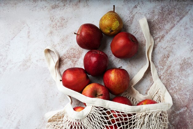 Pommes affamées dans le sac en filet. Durabilité et concept de consommation consciente. Vue de dessus. Mise à plat