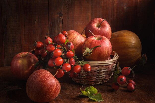 pommes et autres fruits sur fond de bois foncé dans un style rustique