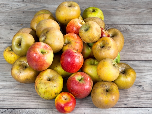 Pommes biologiques rouges et jaunes sur une table en bois