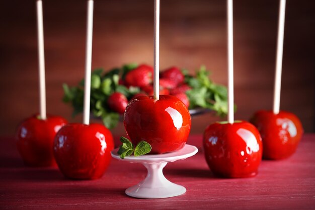 Pommes de bonbons sur une table en bois rouge