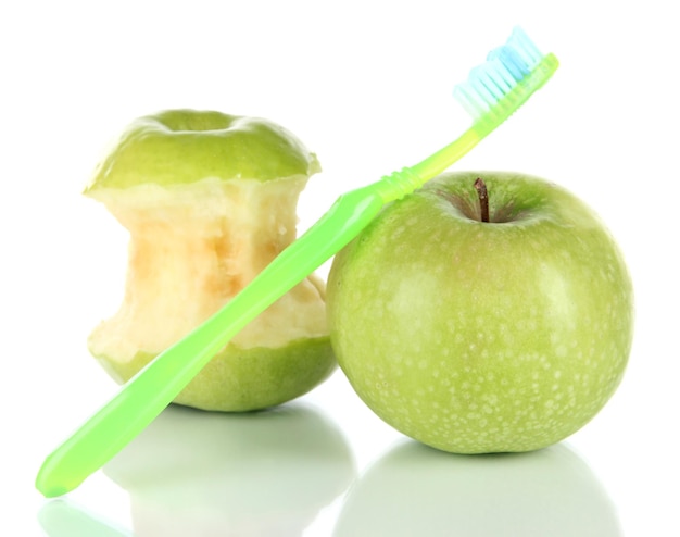 Pommes avec une brosse à dents isolées sur blanc