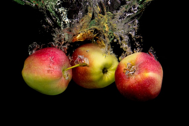 Pommes dans l'eau sur un mur noir