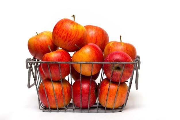 Pommes dans un panier sur fond blanc