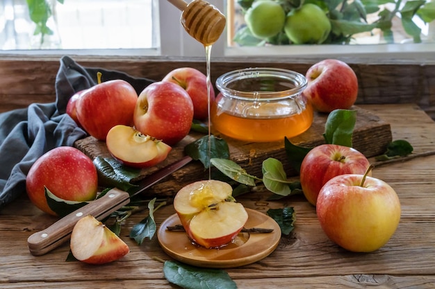 Pommes avec des feuilles de miel sur la table en bois