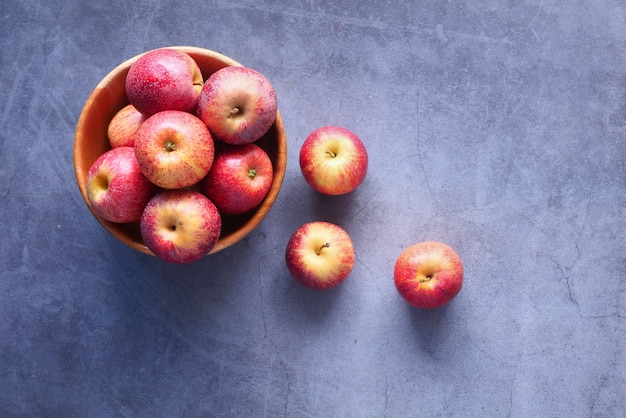 Pommes fraîches dans un bol sur une table en bois