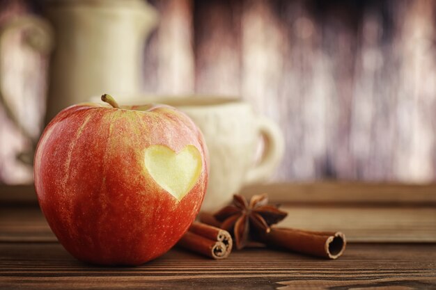 Pommes fraîches sur une planche de bois. Récolte de pommes rouges. Fruits et cannelle sur la table.