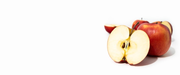 Photo pommes fraîches rouges entières et coupées sur la vue de côté de fond blanc bannière