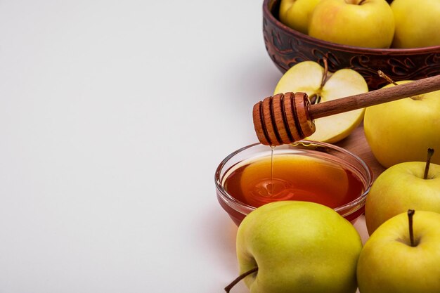 Des pommes jaunes entières et coupées fraîches avec du miel se trouvent sur la table. Mise au point sélective. Espace de copie.