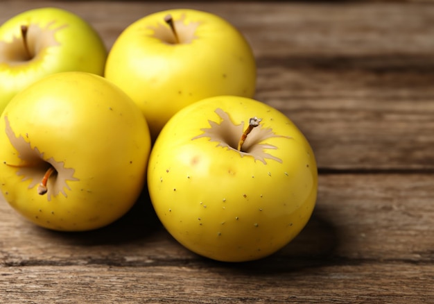 Photo pommes jaunes mûres sur table en bois