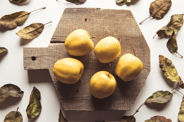 Pommes jaunes sur une planche en tranches dans un style vintage. feuilles, nourriture, nourriture saine, végétalienne, produit de la ferme.