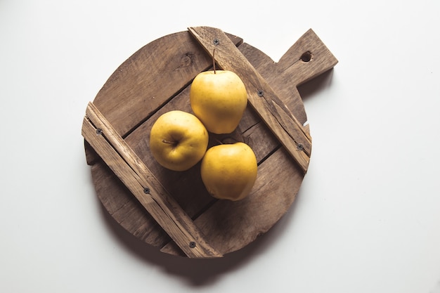 Pommes jaunes sur une planche en tranches dans un style vintage. feuilles, nourriture, nourriture saine, végétalienne, produit de la ferme.