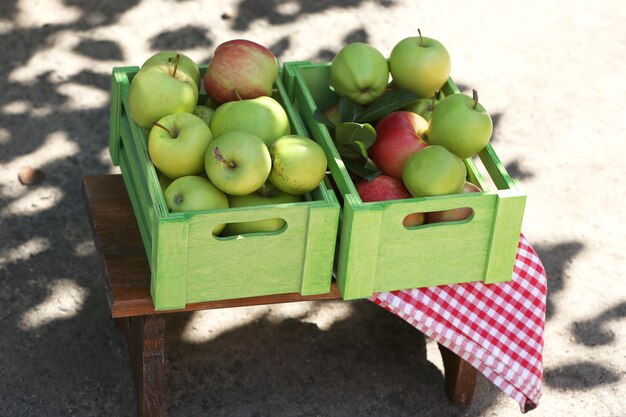 Pommes juteuses dans une boîte en bois à l'extérieur