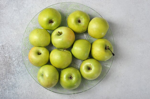 Pommes juteuses entières vertes sur une plaque