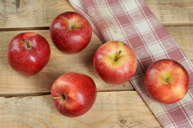 Pommes juteuses rouges sur fond en bois