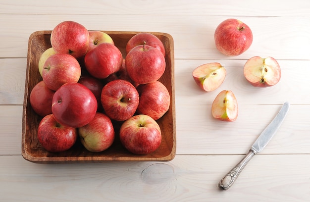 Pommes mûres rouges dans une assiette sur une surface en bois
