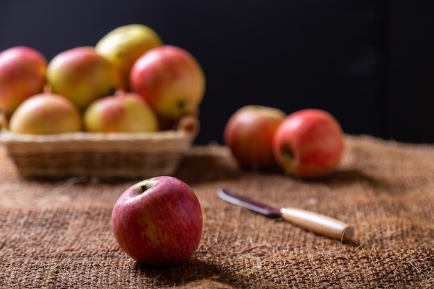 Pommes mûres sur toile de jute et dans un panier