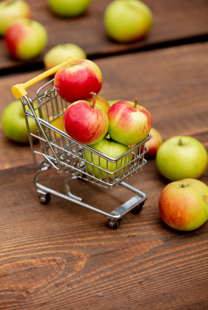 Pommes en petit panier sur un bureau en bois dans un jardin