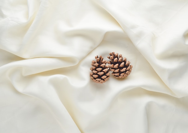 Pommes de pin sur un drap blanc. Matin de noël.