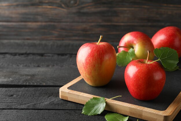 Pommes et planche à découper sur table en bois