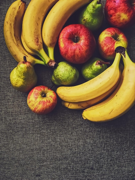 Pommes poires et bananes biologiques sur fond de lin rustique