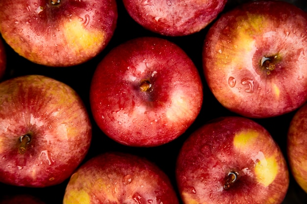 Pommes rouges biologiques fraîches sur fond noir.