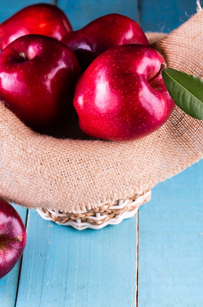 Pommes rouges avec des feuilles sur la table