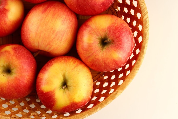 Pommes rouges Florina dans un panier sur une surface blanche