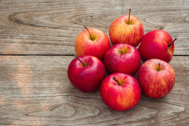 Pommes rouges sur un fond de table en bois